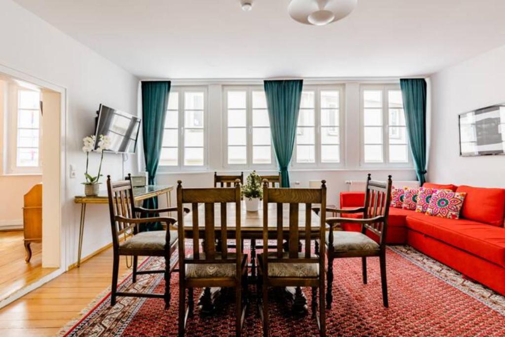 a dining room with a table and a red couch at Apartment Zentral in Tübingen