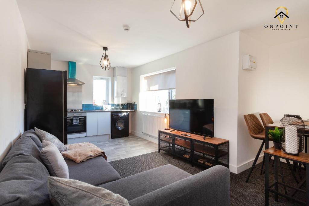 uma sala de estar com um sofá e uma televisão em Modern 3-Storey House With Free Parking! em Birmingham