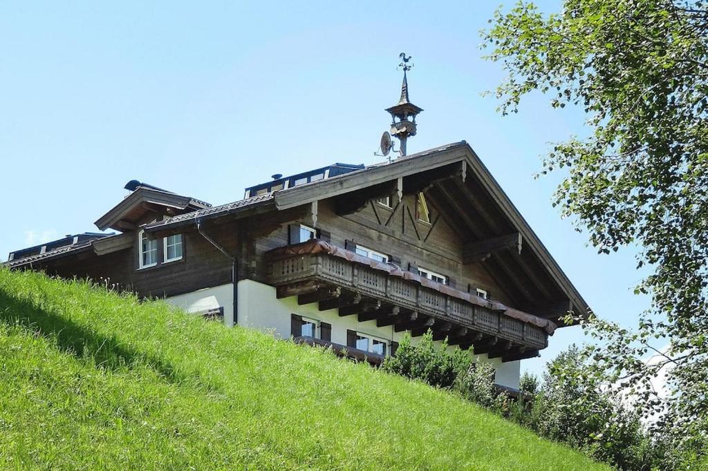 un edificio en una colina con una cruz en el techo en Landhaus Salzburg, Dienten, en Dienten am Hochkönig