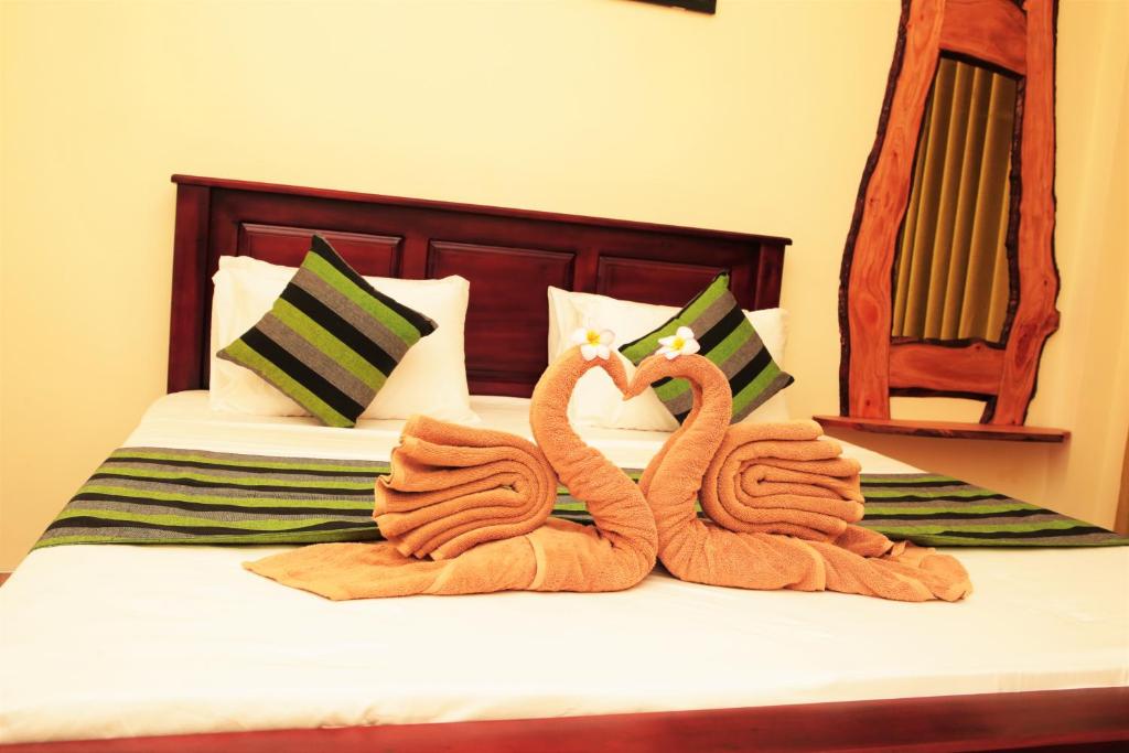 dos cisnes de toalla sentados en la parte superior de una cama en Odani Villa, en Weligama
