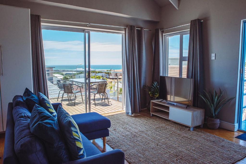 a living room with a couch and a television at Harbour Cottages, Humewood in Port Elizabeth