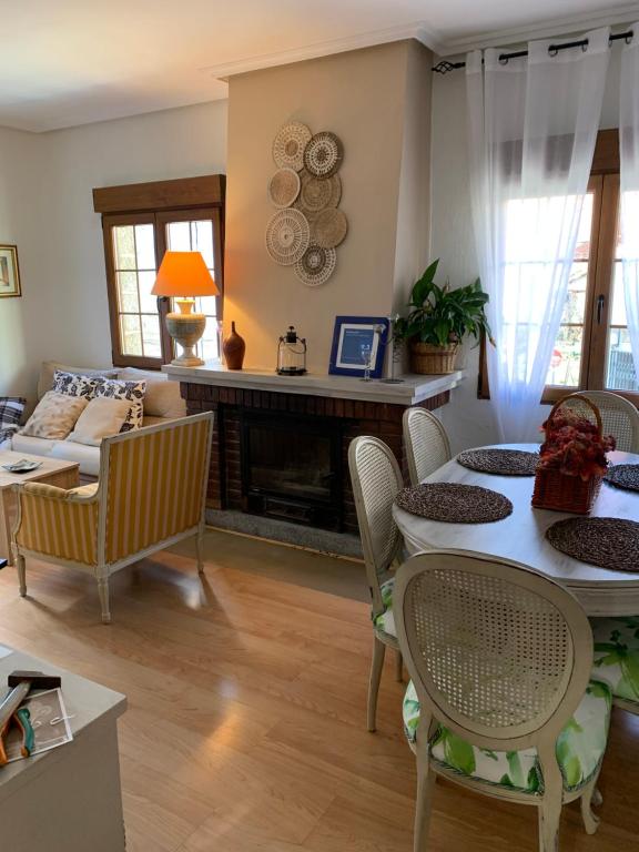 sala de estar con mesa, sillas y chimenea en El balcón de Araceli, en Cercedilla