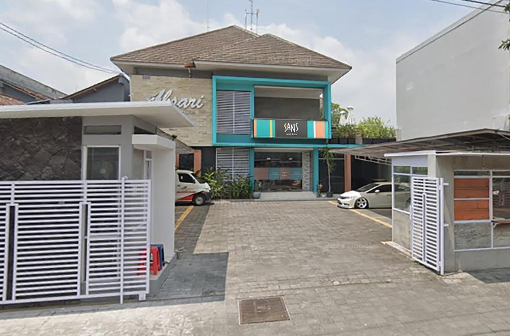 a house with a parking lot in front of it at Sans Hotel Absari Yogyakarta in Durenan