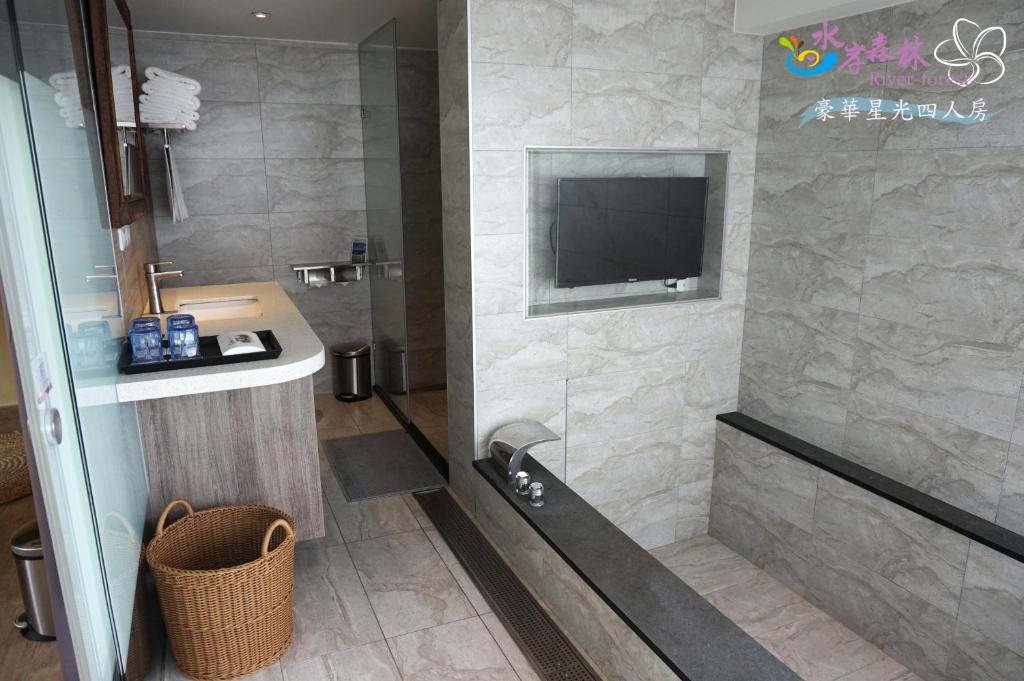 a bathroom with a shower and a sink and a television at River Forest Leisure Farm in Dongshan