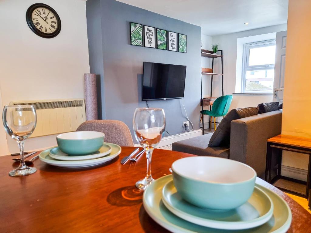 a dining room table with two bowls and wine glasses at New Refurb Top Floor Flat in Central Cheltenham in Cheltenham
