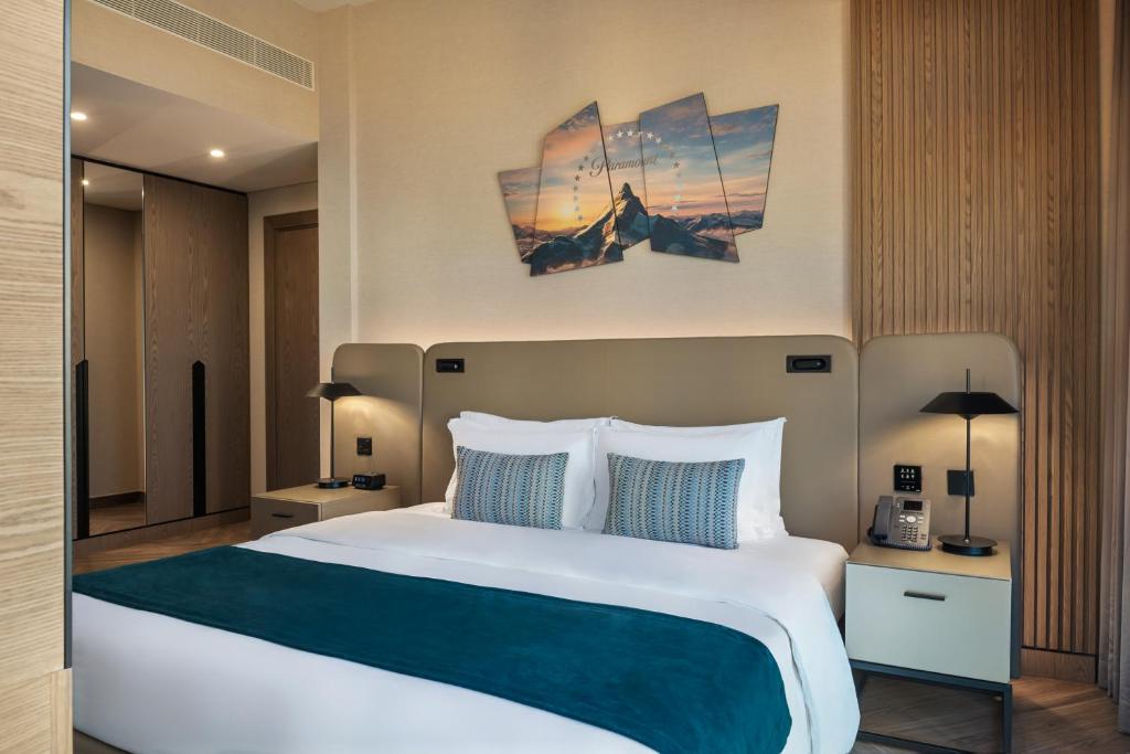 a bedroom with a large bed with blue and white pillows at Paramount Hotel Midtown in Dubai