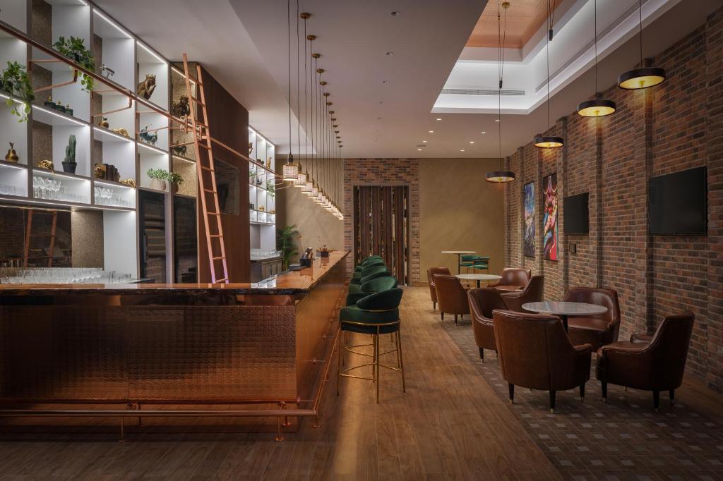 a bar in a restaurant with chairs and tables at Paramount Hotel Midtown in Dubai