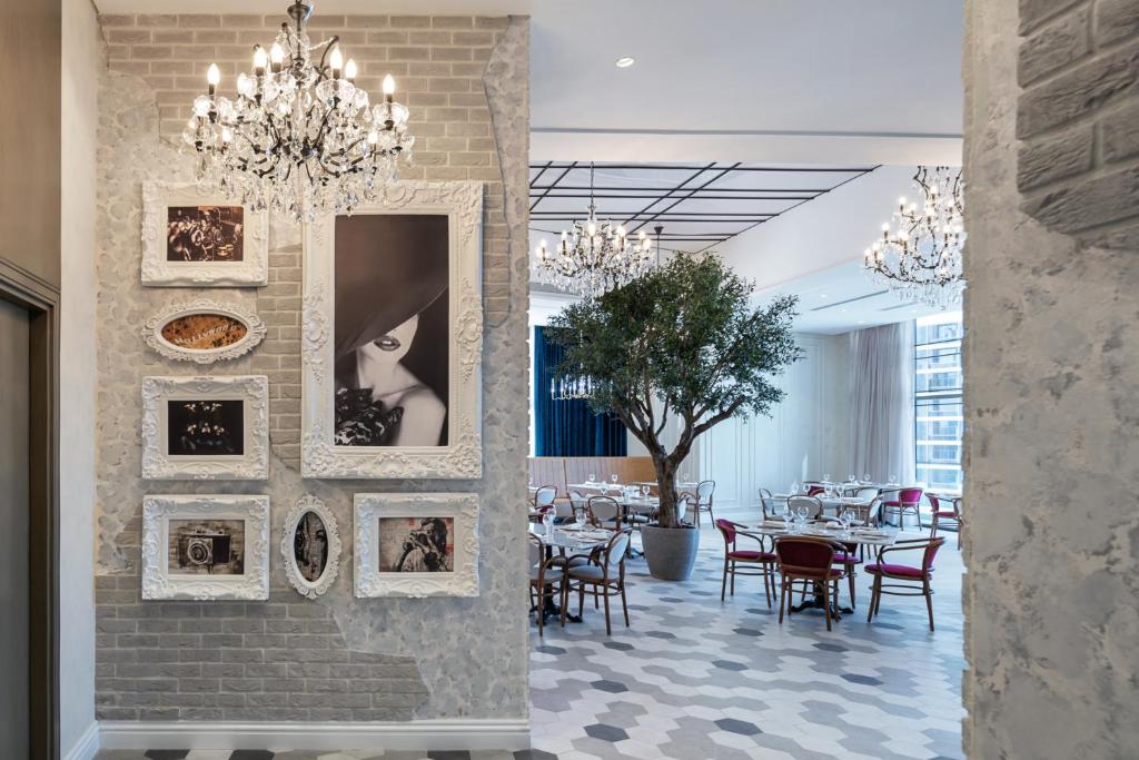 a dining room with tables and pictures on the wall at Paramount Hotel Midtown in Dubai