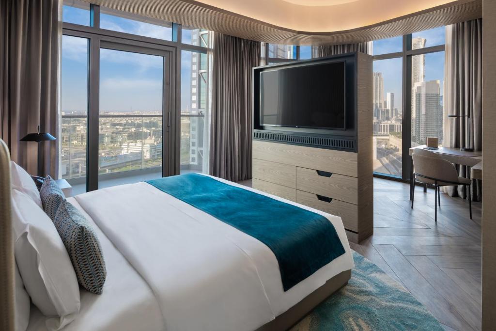 a hotel room with a large bed and a television at Paramount Hotel Midtown in Dubai