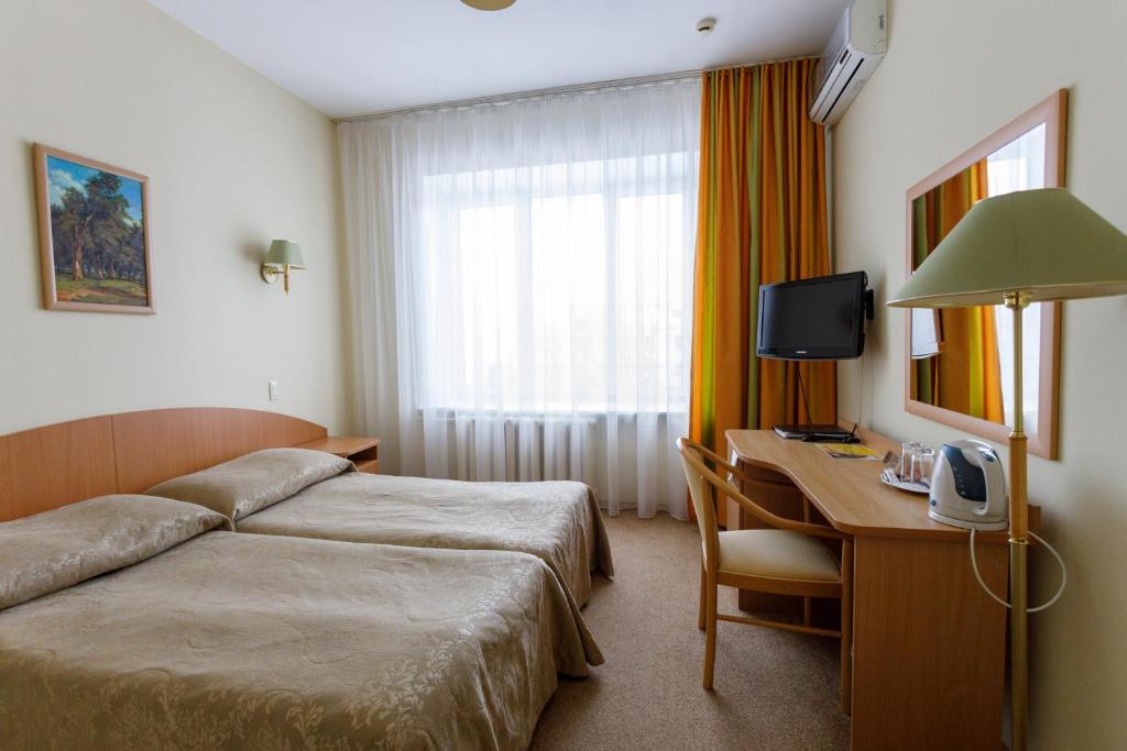 Habitación de hotel con cama y escritorio con ordenador en Hotel Atal, en Cheboksary