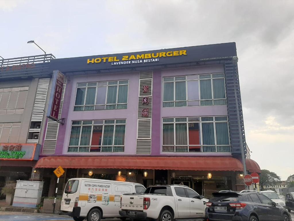un hotel rancourt con coches estacionados frente a él en Lavender Inn Nusa Bestari, en Johor Bahru