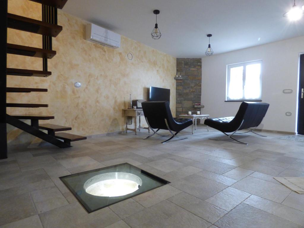 una sala de estar con sillas y una escalera de caracol en Hisa STERNA - WELL HOUSE, en Zgornje Škofije