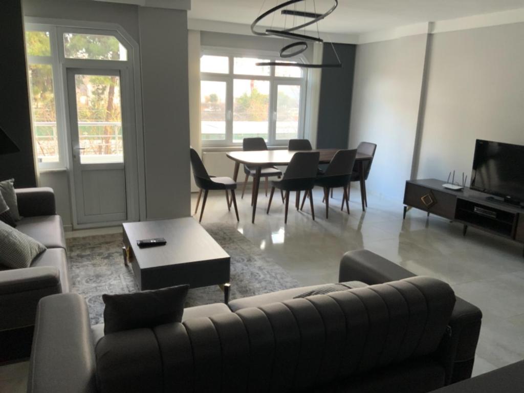 ein Wohnzimmer mit einem Sofa, einem Tisch und Stühlen in der Unterkunft Luxury Z-Apart Family Homes 2 Bedrooms WIFI near Metro Zeytinburnu Istanbul in Istanbul