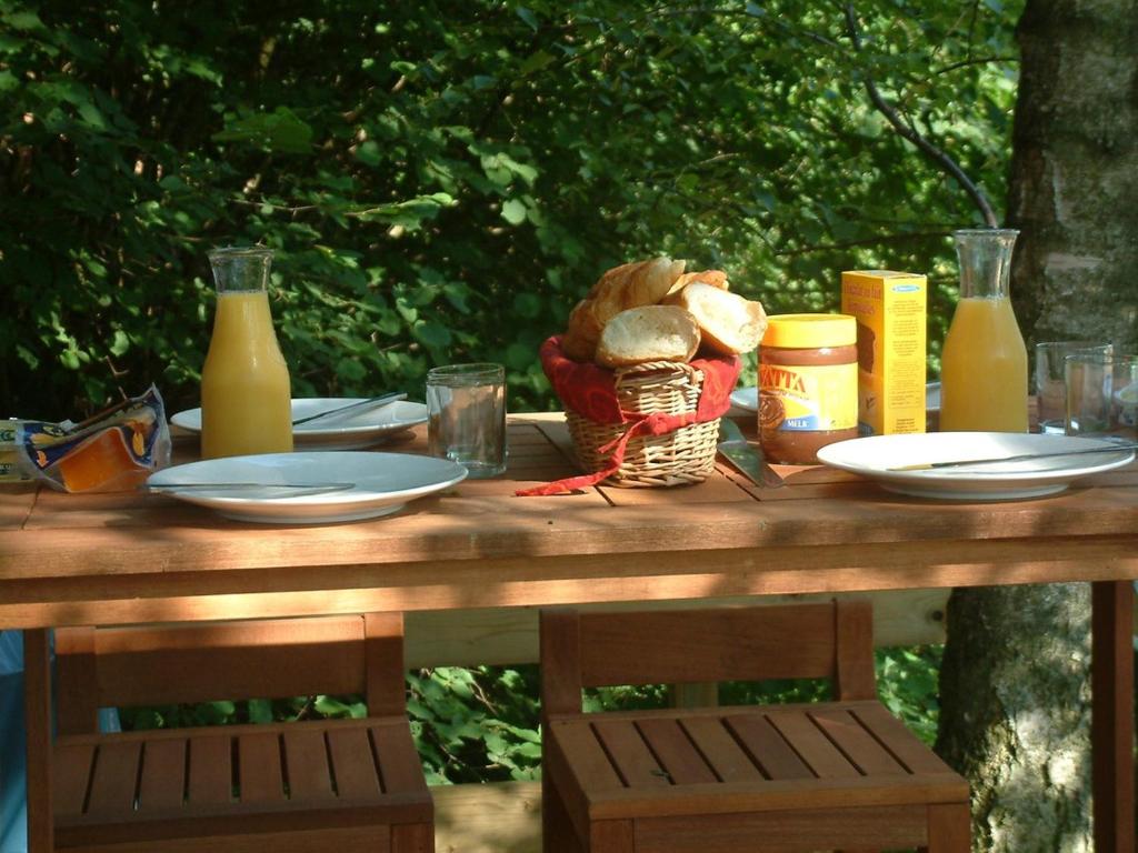 una mesa de picnic con platos de comida y botellas de zumo en Gezellige Chalet met groot zonneterras in Domaine du Bonsoy - vernieuwd in 2024, en Blaimont