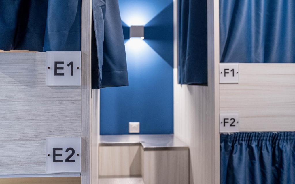 a mirror in a room with blue walls and blue curtains at The Rose Hostel in St. Julianʼs