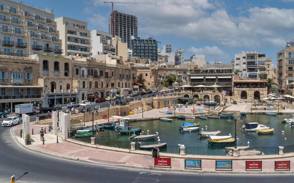 a marina with boats in the water in a city at The Rose Hostel in St. Julianʼs