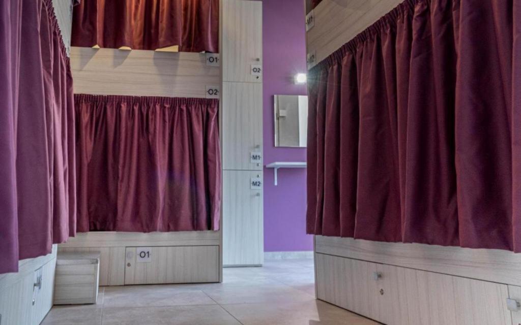 a room with purple walls and red curtains at The Rose Hostel in St. Julianʼs