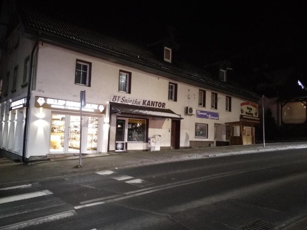 un edificio sul lato di una strada di notte di Apartament Rondo a Karpacz