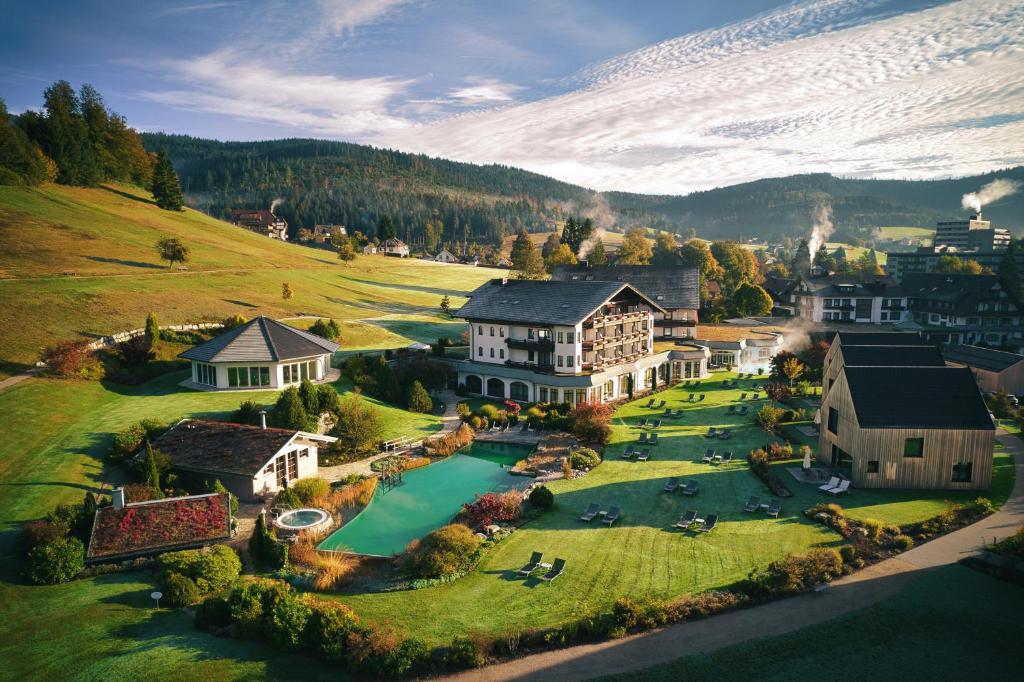 eine Luftansicht eines großen Hauses mit Pool in der Unterkunft Wellness & Genuss Resort - Engel Obertal in Baiersbronn