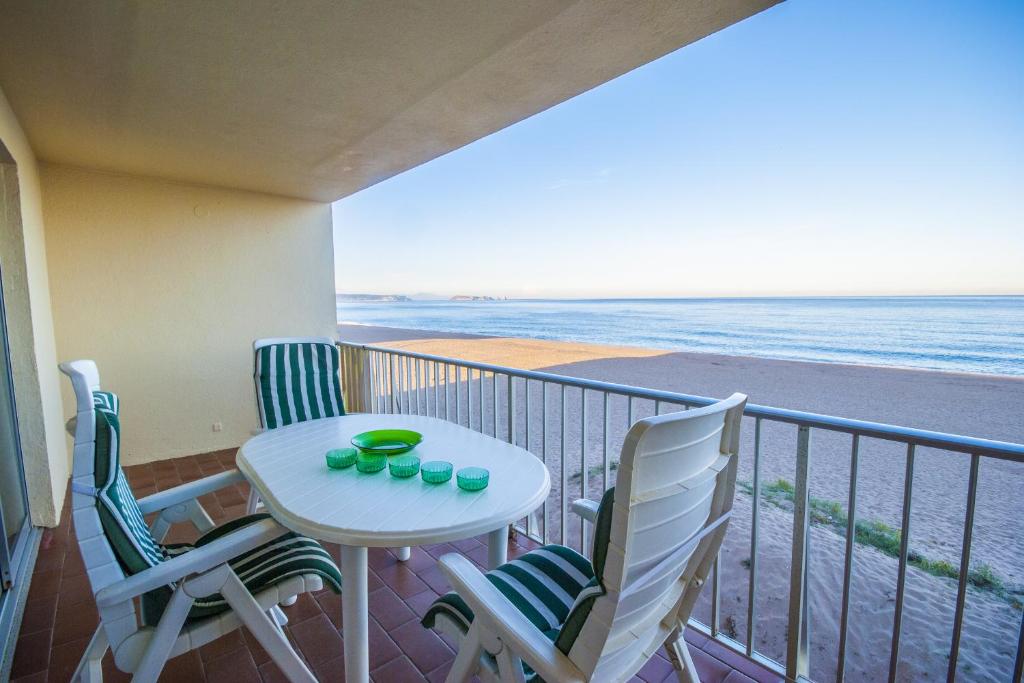uma varanda com mesa e cadeiras e a praia em 1 Med 17 - Pals em Pals