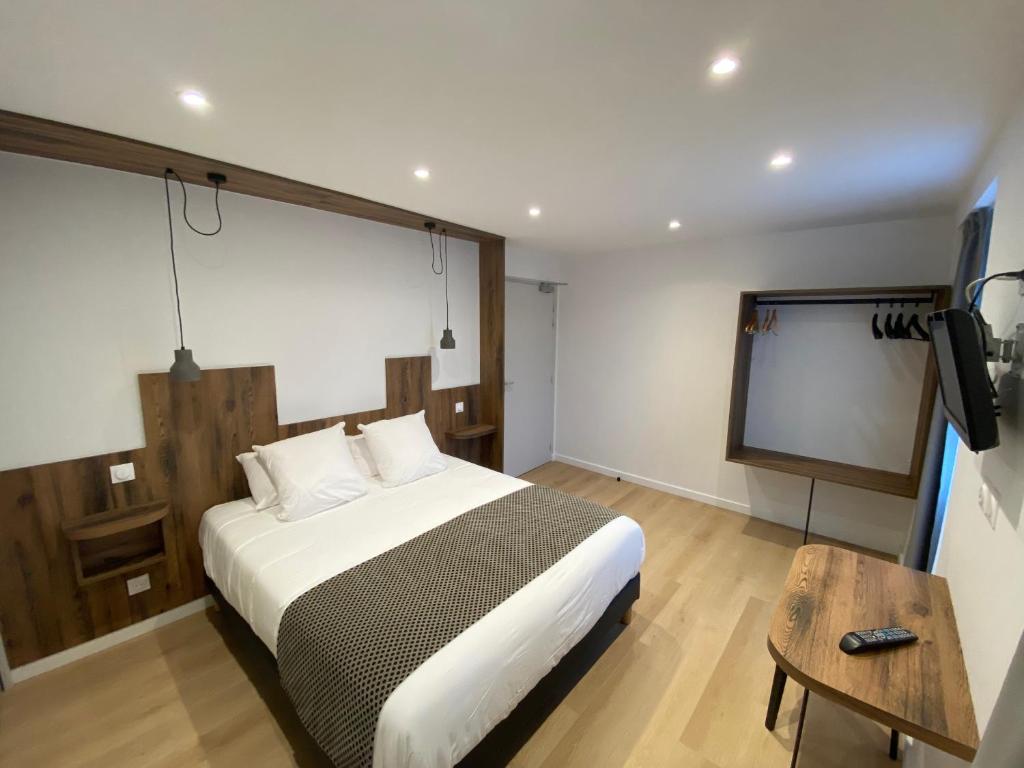 a bedroom with a bed and a flat screen tv at Hotel Restaurant Noblia in Bidarray