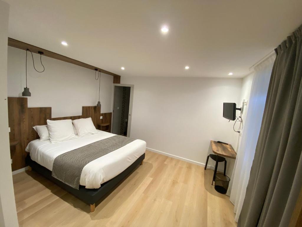 a bedroom with a large bed and a wooden floor at Hotel Restaurant Noblia in Bidarray