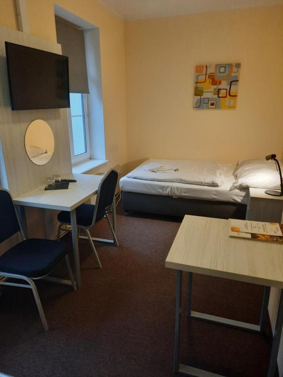 Cette chambre comprend un lit, une table et des chaises. dans l'établissement Tom&Tom, à Białogard