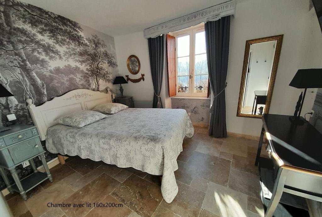 um quarto com uma cama, um espelho e um piano em B&B Manoir de la Fabrègues em Estaing
