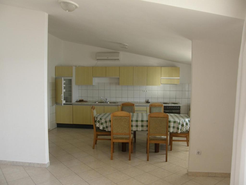 a kitchen with a table and chairs in a room at Apartments IVAN in Duce (900) in Duće