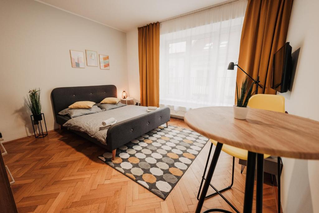 1 dormitorio con cama, mesa y mesa en Elegant studio, 400m from the square en Plzeň