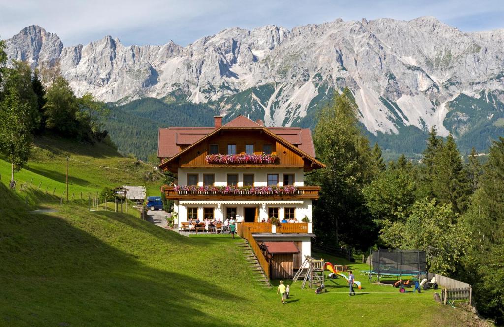 uma casa numa colina com montanhas ao fundo em Bankwirt em Schladming