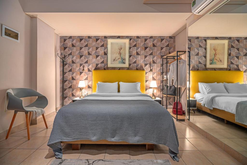 a bedroom with two beds and a chair at Zen Hotel in Athens