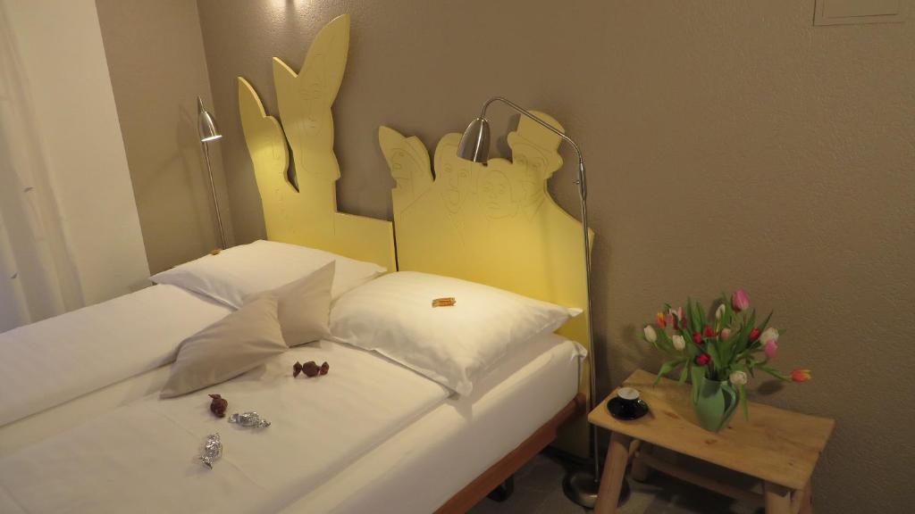 ロカルノにあるResidenza Mottaのベッドルーム1室(ベッド1台、花のテーブル付)