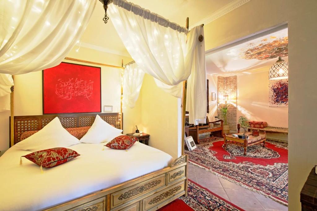 a bedroom with a bed with white sheets and red pillows at L'écrin de Rûmi in Vaires-sur-Marne