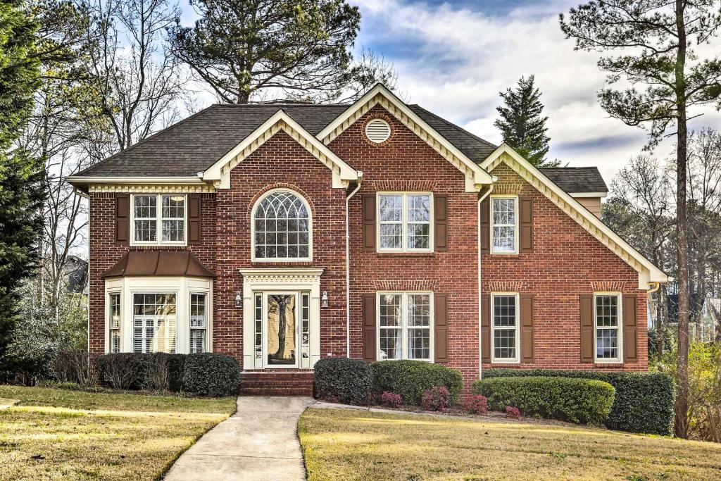 a red brick house with a driveway at Expansive Lawrenceville Home with Private Backyard! in Lawrenceville