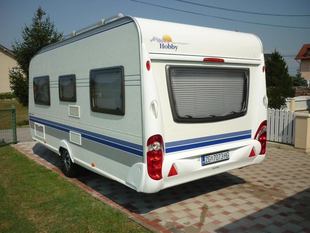 una caravana blanca estacionada en una entrada en Hoby4, en Trogir