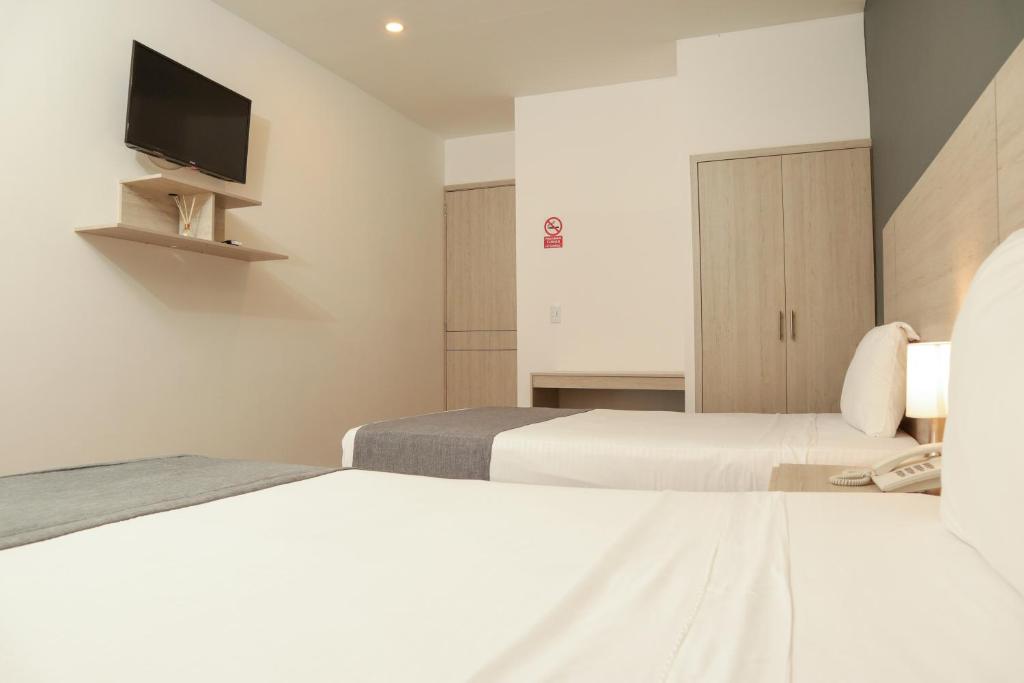 Postel nebo postele na pokoji v ubytování Diagonal Hotel Chipichape