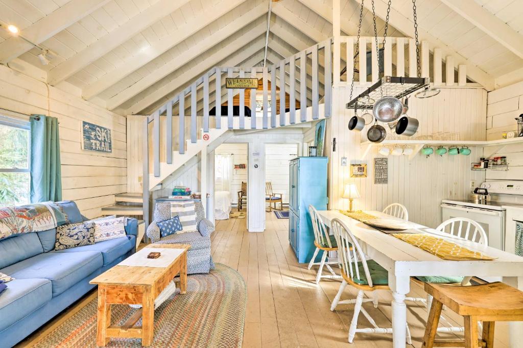 ein Wohnzimmer mit einem blauen Sofa und einem Tisch in der Unterkunft Lakewood Cottage with Private Lake Access and Canoes! in Lakewood