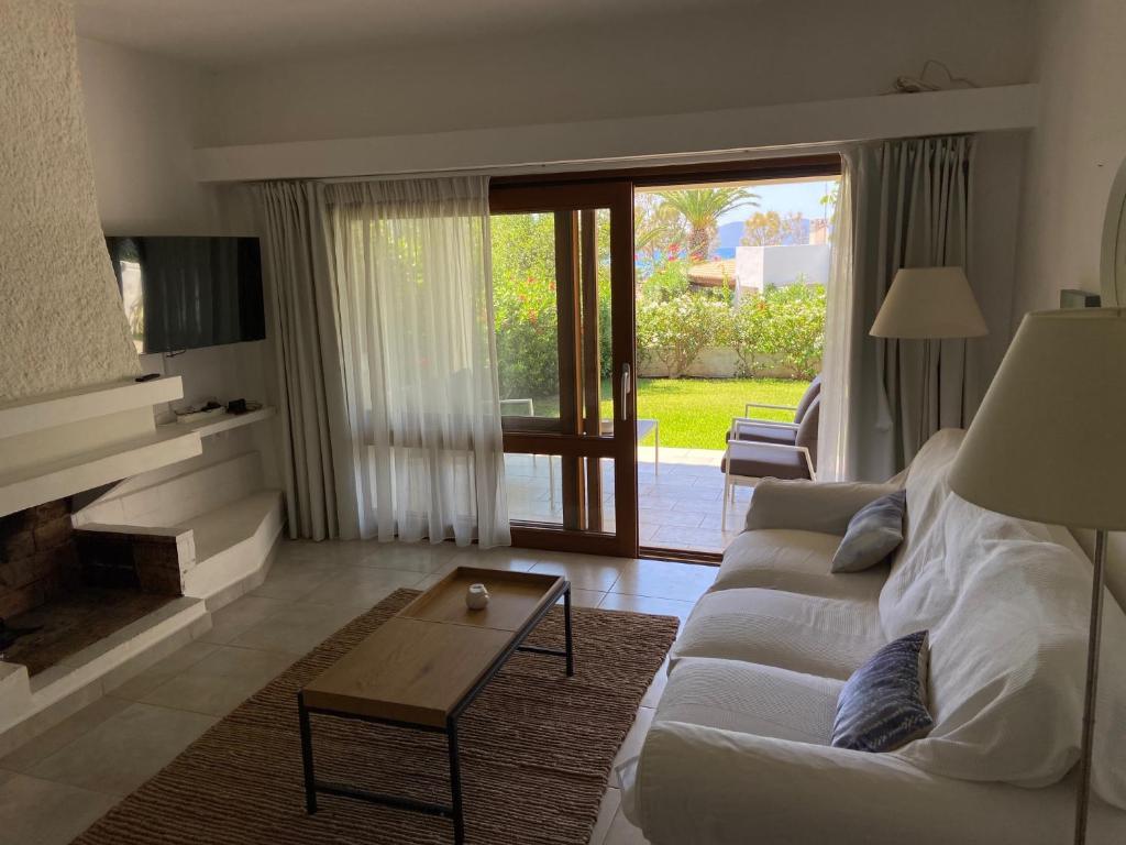 a living room with a white couch and a fireplace at VILLA 21 in Thermisía