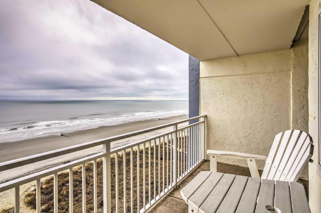 a white chair sitting on a balcony overlooking the beach at Direct Beach Access North Myrtle Condo! in Myrtle Beach