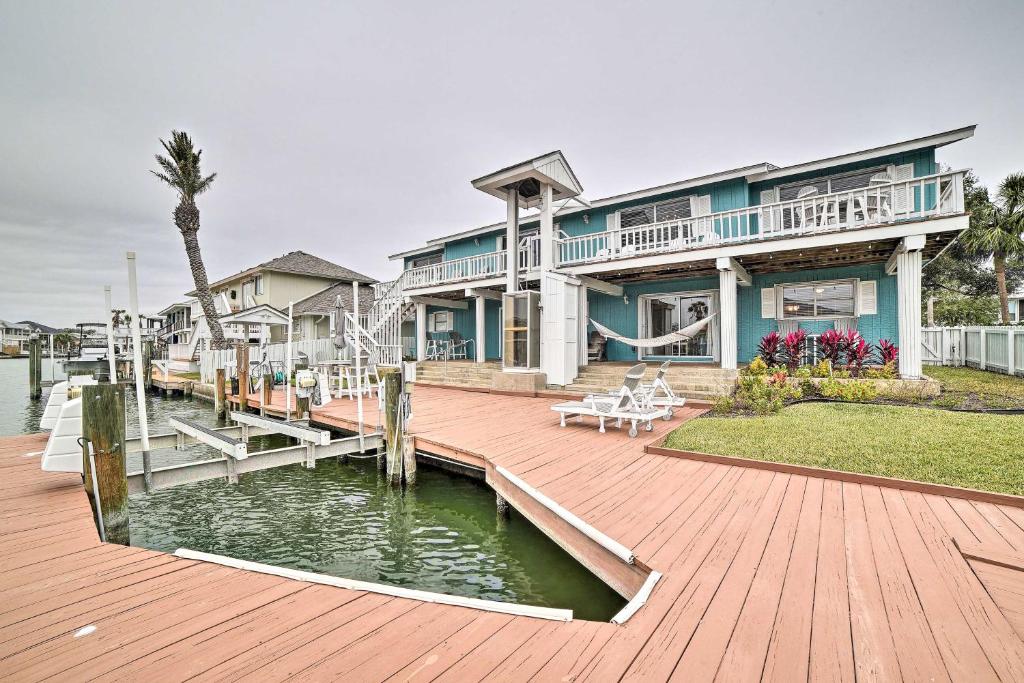 Una casa grande con terraza de madera junto al agua. en Private Dock Charming and Spacious Rockport Abode!, en Rockport