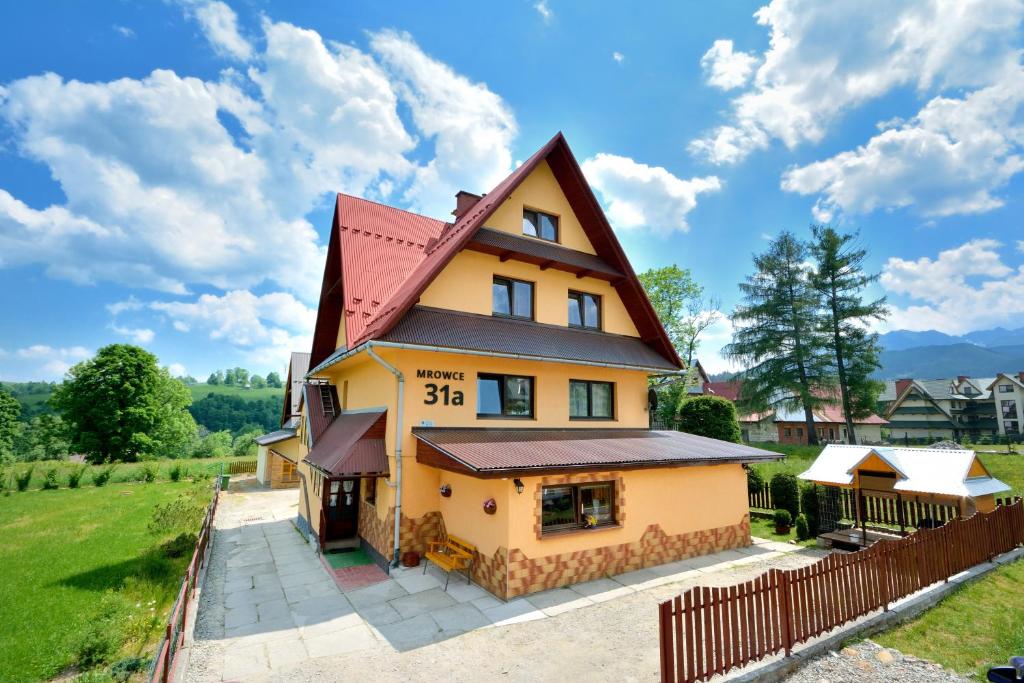 una gran casa amarilla con techo rojo en Pokoje u Tylków en Zakopane