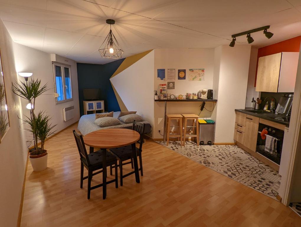 a living room with a table and a kitchen at Ton Petit Studio - Le 62 - Coeur de Ville in Mulhouse