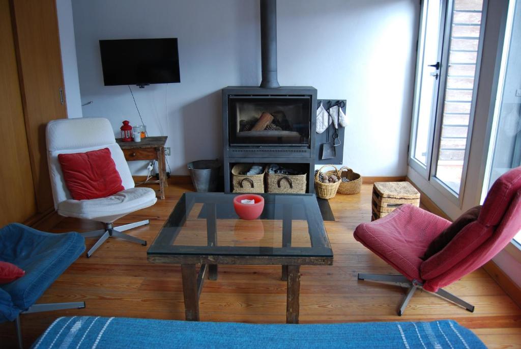 ein Wohnzimmer mit einem Tisch, 2 Stühlen und einem Kamin in der Unterkunft CASA DE DOÑA MARIA VALDELARCO in Valdelarco