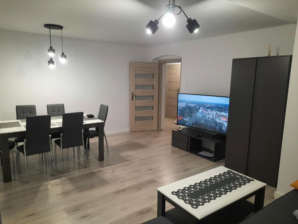Una sala de estar con una mesa de comedor y un televisor. en Apartament "U Kasi i Jakuba", en Szklarska Poręba