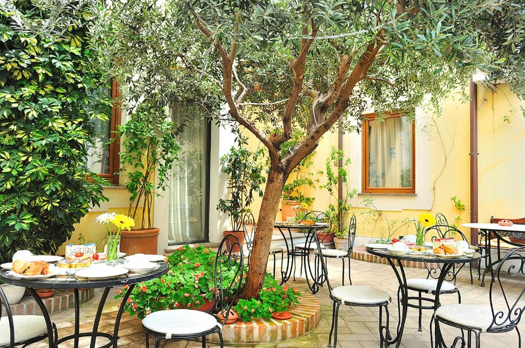 a patio area with tables, chairs, and umbrellas at Relais Le Clarisse in Rome