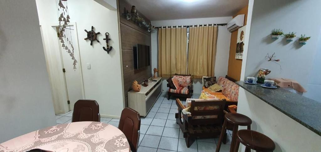 sala de estar con sofá, mesa y sillas en Apartamento na praia de Bombas Edifício Umuarama bloco B, en Bombinhas
