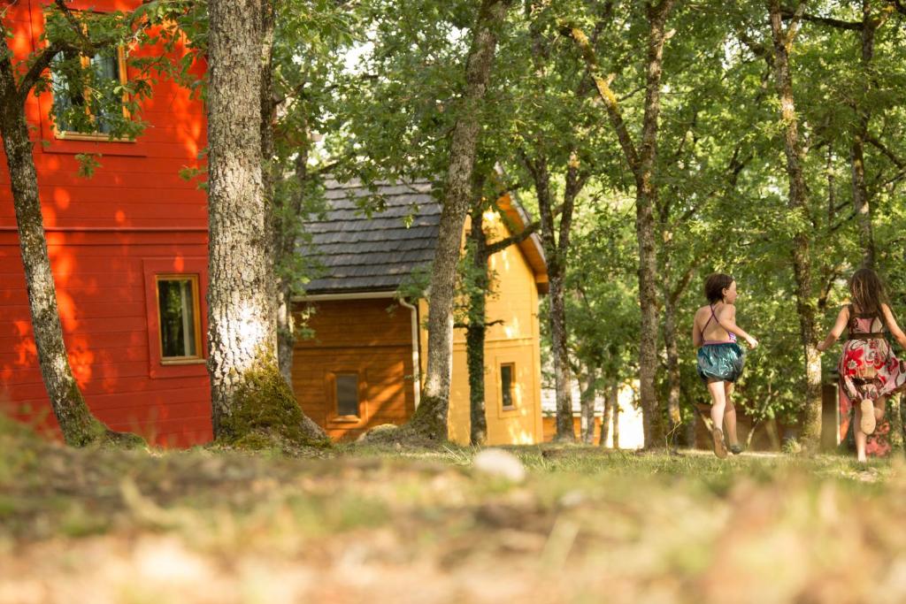 Ein paar Kinder laufen vor einem Haus in der Unterkunft Le Bois de Faral in Le Bastit