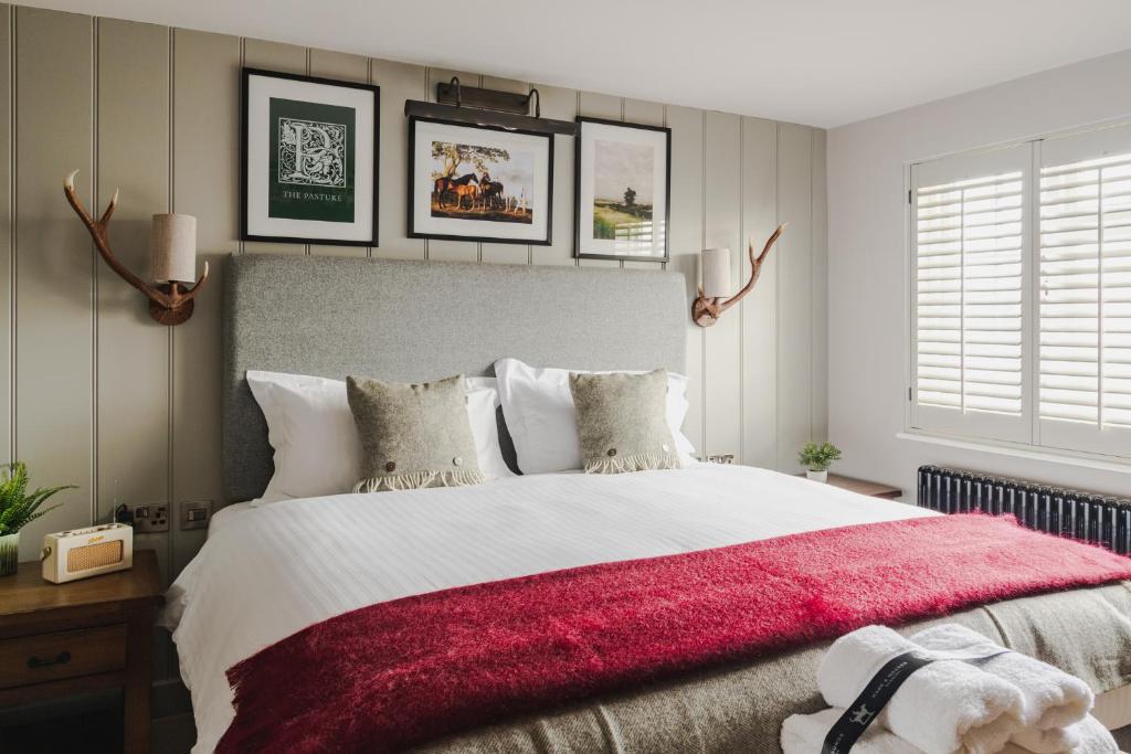 - une chambre avec un grand lit et une couverture rouge dans l'établissement Hare And Hounds Newbury, à Newbury