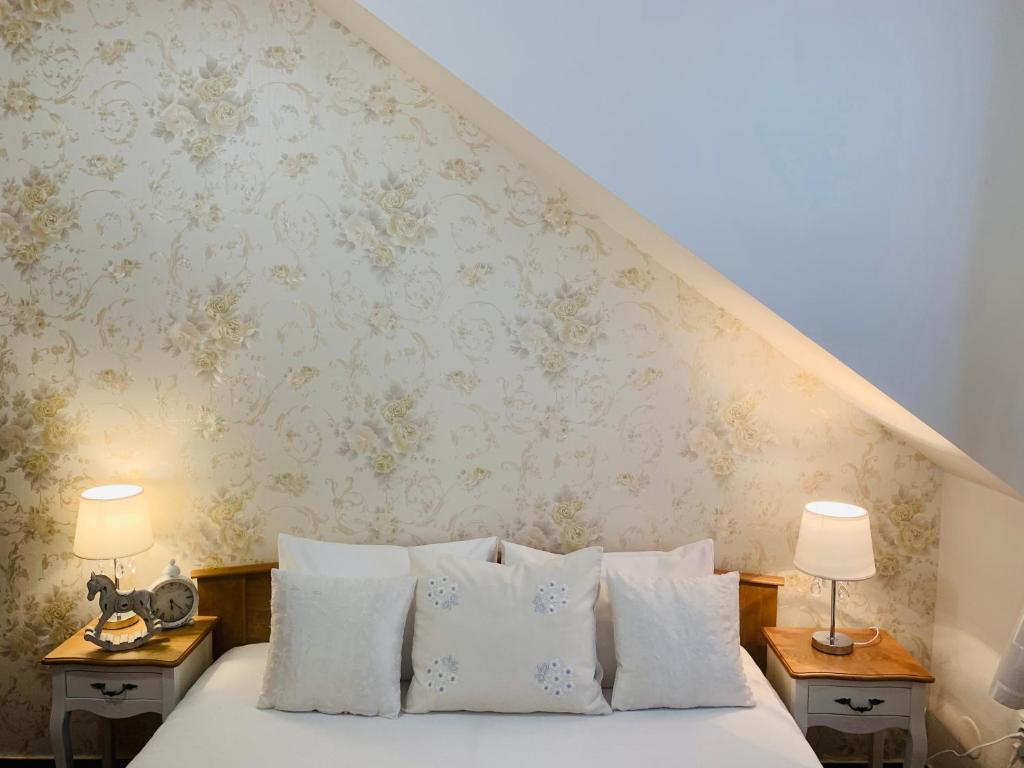 sypialnia z łóżkiem z białymi poduszkami i 2 lampami w obiekcie Hotel Penzion Trámky w mieście Vikýřovice